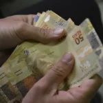 Mão com cédulas de dinheiro