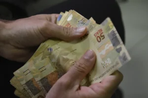 Mão com cédulas de dinheiro