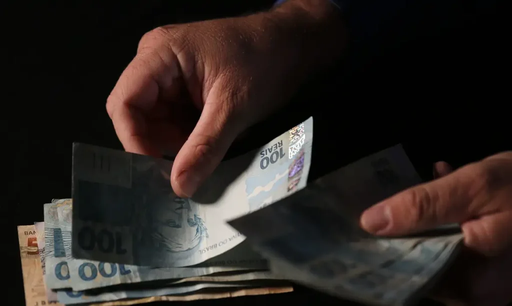 Mão segurando notas de dinheiro