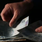 Mão segurando notas de dinheiro