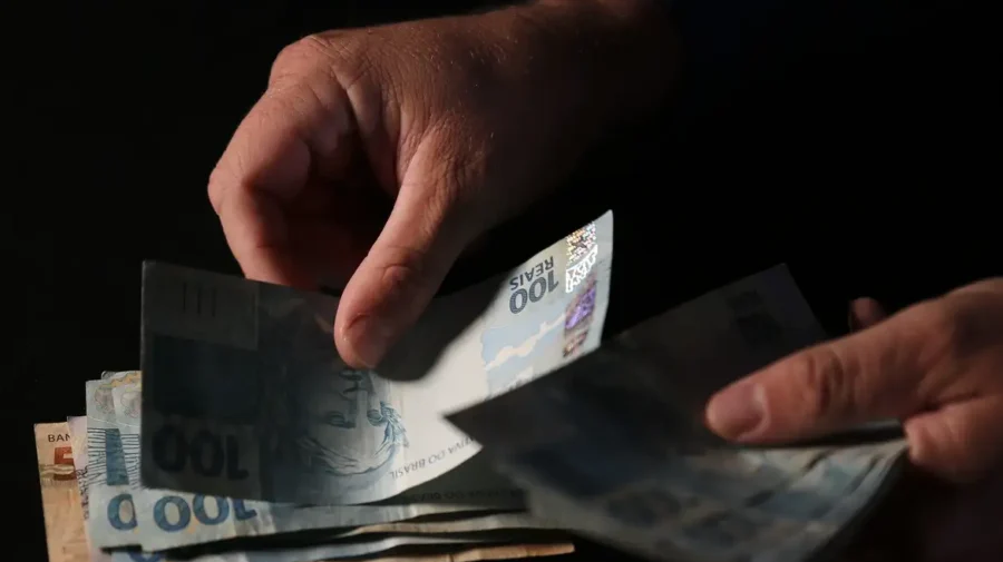 Mão segurando notas de dinheiro