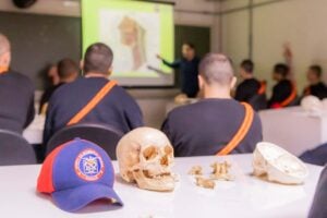 Boné do Corpo de Bombeiros sob uma mesa ao lado de um crânio