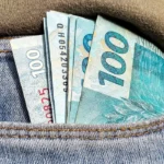 Foto de notas de R$ 100 em um bolso de calça