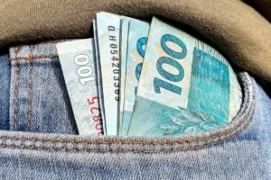 Foto de notas de R$ 100 em um bolso de calça