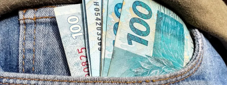 Foto de notas de R$ 100 em um bolso de calça